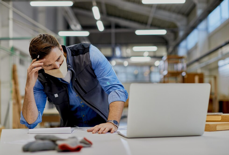 Engineer Problem-Solving at the Desk in a Manufacturing Setting