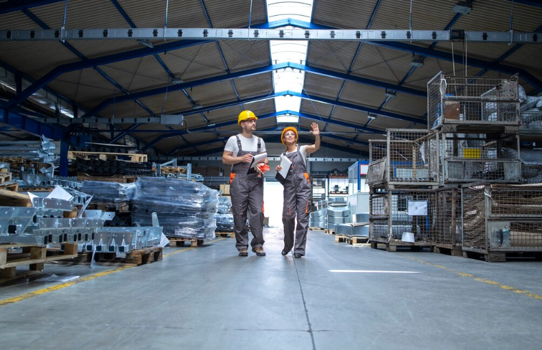 Selective pallet rack manufacturer discussed by two employees planning warehouse upgrade.